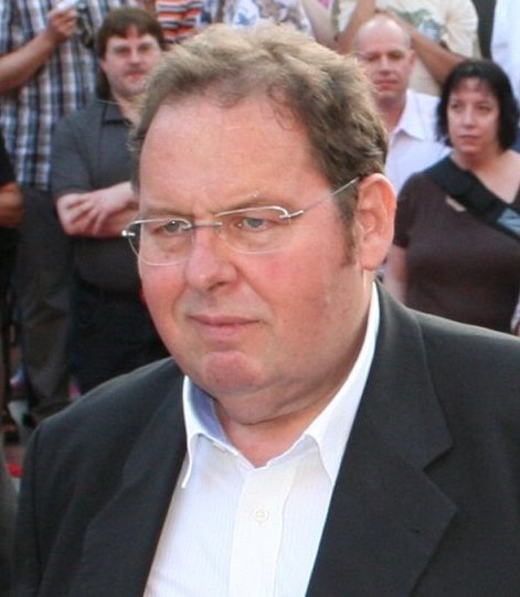 Ottfried Fischer, Vater von Lara Fischer, mit Brille und dunklem Sakko vor Zuschauern bei einer Veranstaltung
